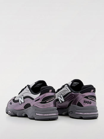 Quattro Stagioni Lifestyle 1000 sneakers in metallic purple and silver with black accents and grey soles.