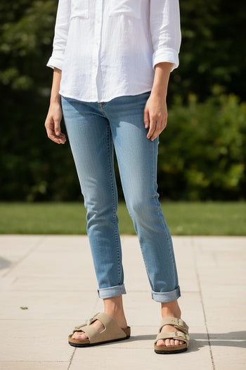 Quattro Stagioni Arizona tan suede sandals with two buckles on a woman wearing light wash cuffed jeans and a white shirt.